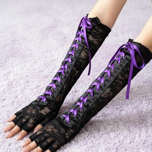 Peut inclure: Gants sans doigts en dentelle noire avec un panneau en satin et un la&ccedil;age en ruban violet. Les gants s'&eacute;tendent jusqu'au coude et pr&eacute;sentent un motif de dentelle florale d&eacute;licate. Un accessoire de mode gothique ou alternatif.