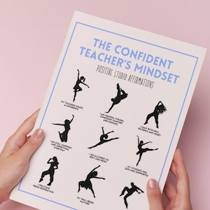 May include: A white poster with a light blue border, held by hands, featuring the text "THE CONFIDENT TEACHER'S MINDSET" and "POSITIVE STUDIO AFFIRMATIONS." It includes black silhouette illustrations of dancers and affirmations such as "My teaching makes a difference."