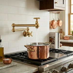 Puede incluir: Un juego de tres tazas de cerámica con un esmalte moteado de color crema. Cada taza presenta un diseño pintado a mano diferente: una hoja azul y verde, una flor amarilla y una baya roja. Las tazas tienen una forma simple y redondeada.