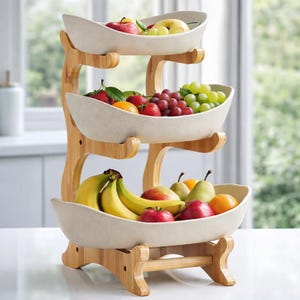 Könnte beinhalten: Ein dreistufiger Obstkorb aus hellfarbenem Bambus und cremefarbenen Schalen. Die Schalen sind mit verschiedenen Früchten gefüllt, darunter Äpfel, Trauben, Erdbeeren, Bananen und Orangen. Der Korb dient zum Halten und Präsentieren von frischem Obst.