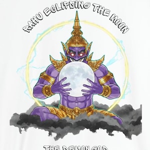 Könnte beinhalten: Weißes T-Shirt mit einer Illustration eines lila Dämongottes, der einen leuchtenden Mond hält. Das Design enthält den Text "RAHU ECLIPSING THE MOON" und "THE DEMON GOD". Der Dämon ist mit Gold geschmückt und sitzt auf dunklen Wolken.