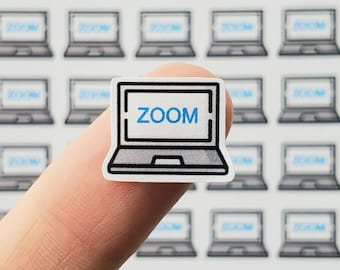 May include: A white laptop sticker with a black outline and the word "ZOOM" in blue text on the screen.