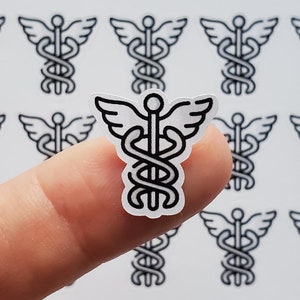May include: A sheet of stickers featuring a black and white outline of the caduceus symbol, a medical symbol with a snake wrapped around a staff with wings.