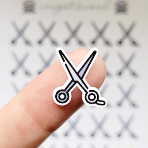 May include: A sticker of a pair of scissors with a white background.