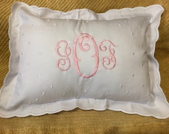 May include: White pillow with a scalloped edge and pink embroidered monogram "YOF".