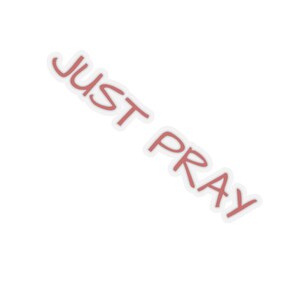 May include: A sticker with the words "JUST PRAY" in a handwritten style, in a reddish-brown color with a white border. The sticker is angled diagonally against a white background.