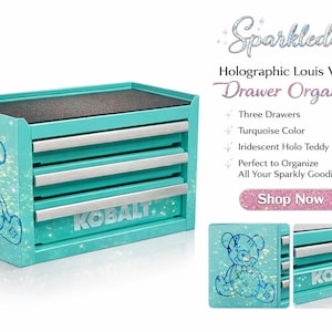 Könnte beinhalten: Ein türkisfarbener Schubladen-Organizer mit drei Schubladen und silbernen Griffen. Der Organizer hat ein schillerndes holografisches Teddybär-Design und das Wort "KOBALT" in Weiß. Die Oberseite ist schwarz.