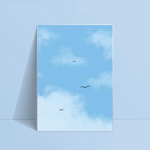 May include: A framed print depicting a bright blue sky with white clouds. Three black birds are in flight. The artwork is leaning against a light blue wall, creating a shadow.