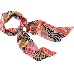 May include: A pink, white, black, and gold patterned scarf with a zebra print design.