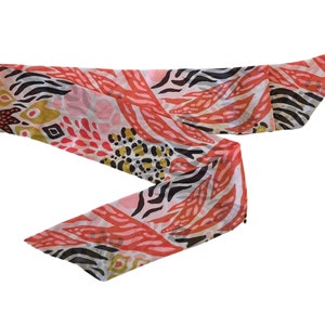 May include: A pink, black, and gold patterned scarf with a zebra print and floral design.