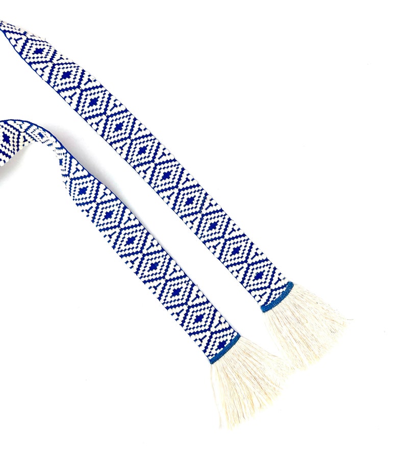 May include: Two blue and white patterned fabric ribbon ties with white fringe ends.