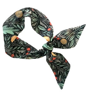 May include: A black fabric headband with a green, orange, and red floral pattern.