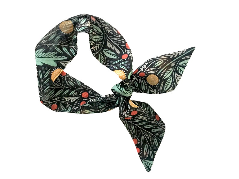 May include: A black fabric headband with a green, orange, and red floral pattern.