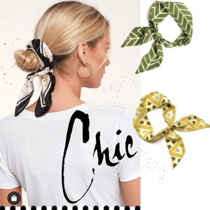 May include: A woman with blonde hair is wearing a white t-shirt with the word "Chic" written in black script. She is wearing a black and white patterned scarf tied around her hair. Two patterned scarves are shown in the background, one green and one yellow.