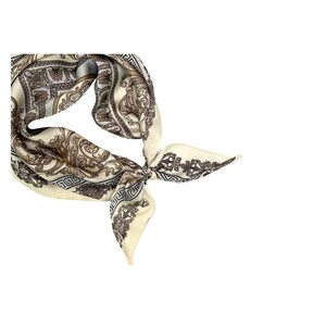 May include: Ivory-colored silk scarf with a detailed baroque pattern in shades of brown and black. The scarf is knotted, showcasing its intricate design and elegant style. A classic accessory.