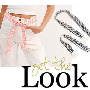May include: A pink and white woven belt with fringe tassels. The belt is tied around a pair of white jeans. The text "get the Look" is written in gold script below the image.
