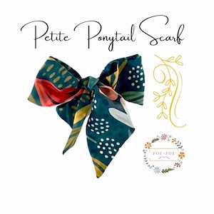 May include: A teal Petite Ponytail Scarf with a floral pattern in red, white, and yellow. The scarf is tied in a bow shape. The text "Petite Ponytail Scarf" is written in a script font.