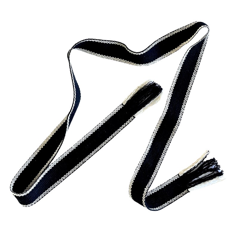 Pu&ograve; includere: Un nastro intrecciato bianco e nero con le estremit&agrave; sfilacciate. Il nastro &egrave; largo circa 3,8 cm e presenta un semplice motivo geometrico.