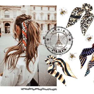 May include: Three different patterned hair scrunchies. The scrunchies are made of fabric and have a bow on top. The scrunchies are in a leopard print, a striped pattern, and a blue and yellow pattern. The image also includes a woman with brown hair wearing a leopard print scrunchie in her hair.