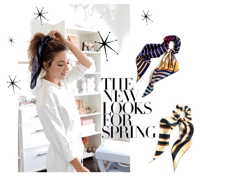 May include: Two colorful patterned hair scrunchies with a bow. The scrunchies are made of silk and have a striped pattern. The text "THE NEW LOOKS FOR SPRING" is visible in the background.