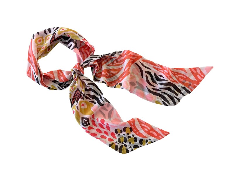 May include: A pink, white, black, and gold patterned scarf with a zebra print design.
