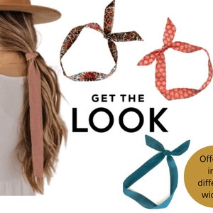 May include: Three fabric headbands in different patterns and colours. The headband on the left is a paisley pattern in shades of red, brown, and white. The headband in the middle is a red headband with a white snowflake pattern. The headband on the right is a solid teal blue. The text "GET THE LOOK" is in the centre of the image. The text "Offered in 3 different widths" is in the bottom right corner of the image.