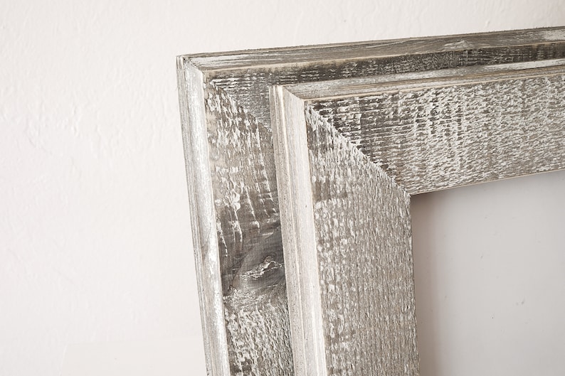 May include: Close-up of a rustic wooden picture frame with a distressed white paint finish. The frame has a simple, rectangular shape and a slightly raised edge.