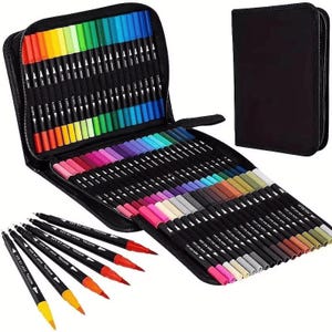 May include: A black zipped case containing a vibrant array of dual-tip markers in various colours. The markers are neatly organised, displaying a wide spectrum of hues. A separate black case is also present. Several markers are outside the case, showing their dual tips.