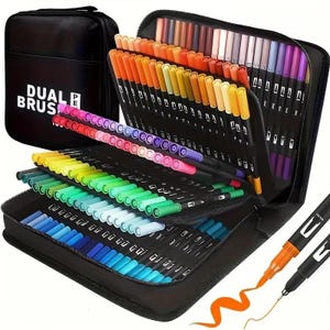 May include: A black zippered case labelled "DUAL BRUSH" holds a collection of dual-tip brush pens in a variety of colours. The pens are neatly arranged, displaying a rainbow of hues. Two pens are shown with ink strokes, demonstrating the pen's dual tip functionality.