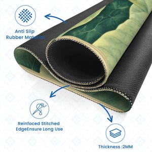 May include: A close-up of a mousepad with a green leaf design. The mousepad has a black anti-slip rubber material base and reinforced stitched edges. The thickness is 2mm.