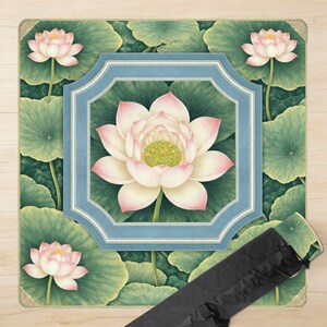 May include: A yoga mat featuring a detailed illustration of lotus flowers and leaves in shades of pink, white, and green. The design includes a central lotus within a blue and white frame, with additional flowers and leaves around the edges. A black carrying bag is included.