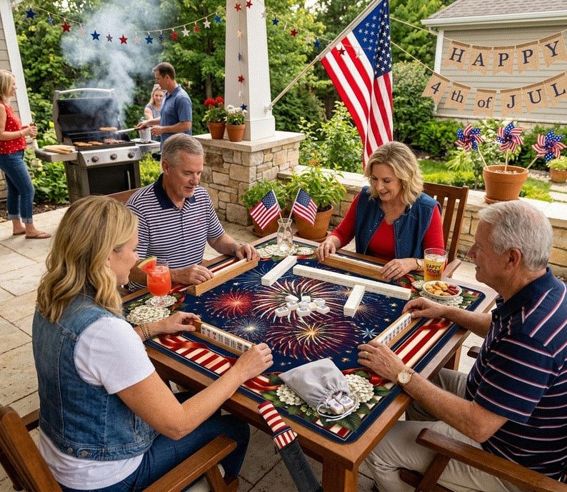 May include: A group of people playing Mahjong at an outdoor table decorated with a patriotic fireworks design. The table is set for a 4th of July celebration, with American flags and festive decorations.