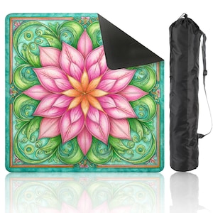 Op de afbeelding: Een yogamat met een groot roze en oranje bloemenontwerp, omgeven door groene en turquoise krullen. De mat heeft een zwarte onderkant en wordt geleverd met een zwarte draagtas met een schouderriem. Het ontwerp van de mat is gedetailleerd en kleurrijk.