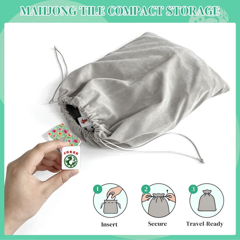 K&ouml;nnte beinhalten: Ein hellgrauer Samtbeutel mit Kordelzug zur kompakten Aufbewahrung von Mahjong-Steinen. Die Tasche hat eine weiche Stoffoberfl&auml;che mit passenden grauen Kordeln. Ein wei&szlig;er Mahjong-Stein mit gr&uuml;nem Drachenmotiv und rotem JOKER-Text.