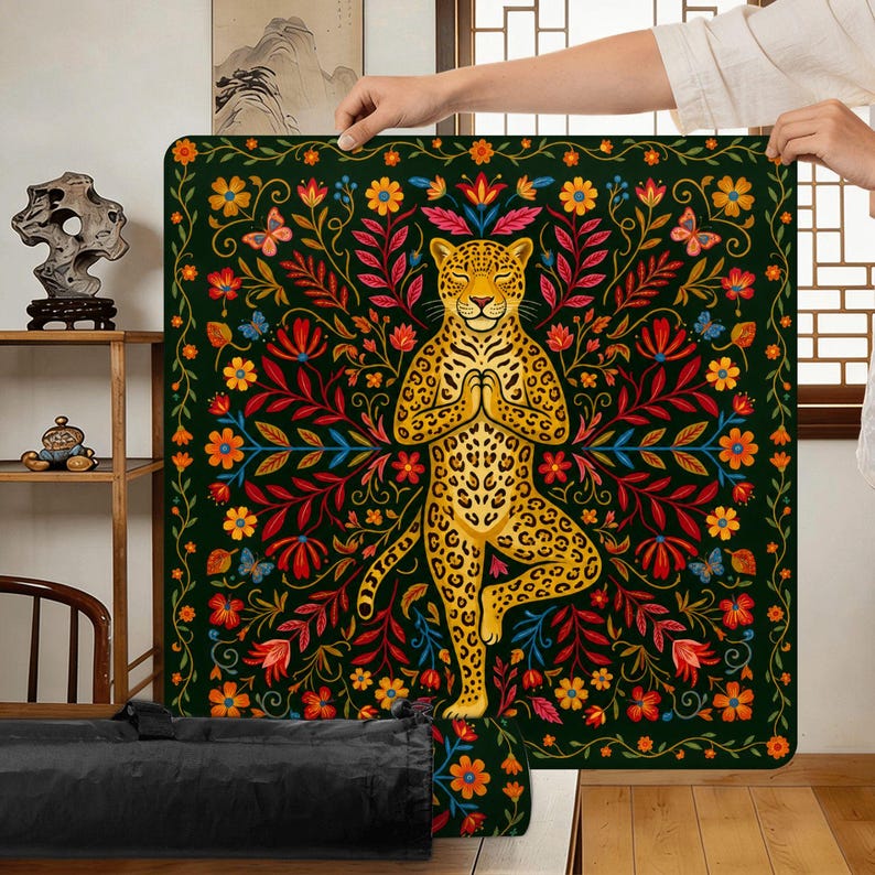 Puede incluir: Una esterilla de yoga cuadrada, verde oscuro, con un leopardo dorado en postura de &aacute;rbol, rodeado de coloridas flores y follaje. El leopardo est&aacute; en una pose meditativa. La esterilla tiene un borde floral.