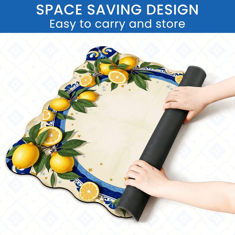 K&ouml;nnte beinhalten: Eine dekorative, aufgerollte Matte mit einem Zitronen- und Bl&auml;ttermuster. Die Matte hat eine cremefarbene Mitte mit einem blau-wei&szlig;en Rand. Der Text "SPACE SAVING DESIGN Easy to carry and store" steht oben. Die Matte wird von zwei H&auml;nden gehalten.