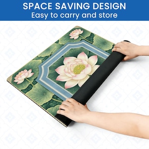 May include: A rolled-up black yoga mat with a floral design featuring lotus flowers and leaves. The mat has a central framed image of a lotus flower. The text at the top says "SPACE SAVING DESIGN Easy to carry and store."