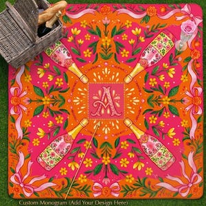 K&ouml;nnte beinhalten: Eine lebendige Picknickdecke in Pink und Orange mit Blumen- und Banddesign. Die Decke zeigt vier Champagnerflaschen, gelbe Blumen und ein zentrales Monogramm. Ein Picknickkorb mit Essen befindet sich in der oberen linken Ecke. Der Text "Custom Monogram (Add Your Design Here)" befindet sich unten.