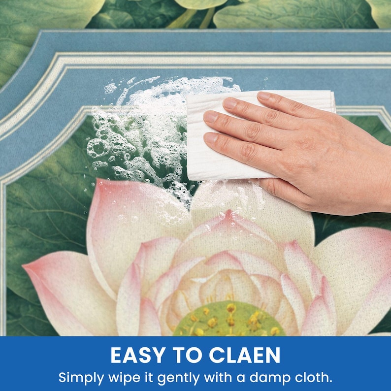 May include: A hand wipes a surface with a white cloth, creating suds. The surface features a floral design with a lotus flower in shades of pink and green. The text "EASY TO CLEAN" is visible at the bottom.