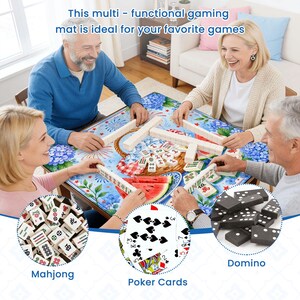 May include: A multi-functional gaming mat with a floral and fruit design. The mat is being used by four people playing Mahjong, poker, and dominoes. The text on the mat reads "This multi - functional gaming mat is ideal for your favorite games."