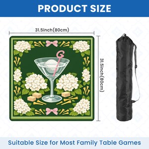 Peut inclure: Un tapis de jeu vert, carr&eacute; de 80 cm, repr&eacute;sentant un verre &agrave; martini avec une balle de golf et un b&acirc;tonnet rose, entour&eacute; de fleurs blanches et de tees de golf. Comprend un sac de transport noir. Le texte indique "PRODUCT SIZE" et "Suitable Size for Most Family Table Games."