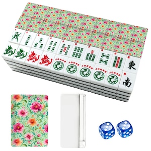 K&ouml;nnte beinhalten: Ein Set aus Mahjong-Spielsteinen mit einem Blumenmuster auf der R&uuml;ckseite in Rosa-, Orange- und Gr&uuml;nt&ouml;nen. Die Vorderseite der Steine zeigt verschiedene gr&uuml;ne und rote Symbole, Drachenillustrationen, das Wort JOKER und schwarze Schriftzeichen.