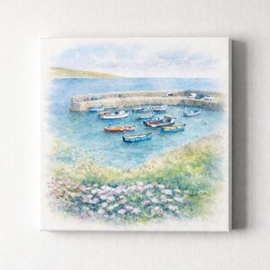 May include: Watercolor painting of a harbor scene with small boats docked in the water. A stone pier extends into the blue water, and a green hillside is in the background. Pink and white flowers are in the foreground.