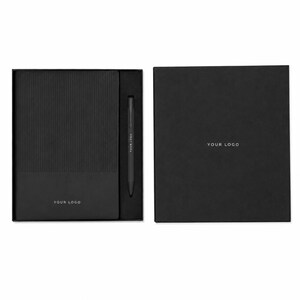 Puede incluir: Un set de regalo negro que contiene un cuaderno rectangular con textura acanalada en la mitad superior y una mitad inferior lisa, un bolígrafo negro a juego y una caja de presentación negra. El texto YOUR LOGO está impreso en el cuaderno, el bolígrafo y la caja.