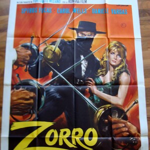 May include: A vintage movie poster for the film "Zorro Alla Corte D'Inghilterra" featuring a masked man in black holding a sword and a woman in a green dress. The poster has a yellow and black color scheme and features the title of the film in large, bold letters.