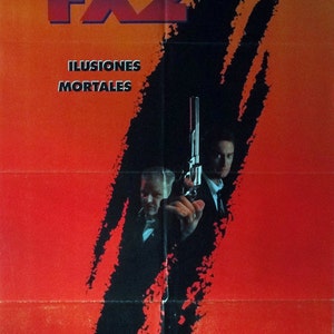 May include: A movie poster for the film "FX2: Illusions Mortales" featuring a red background with black paint splatters. The title "FX2" is in large, bold, purple and blue letters. The text "Illusions Mortales" is in smaller, white letters. Two men are shown in the poster, one holding a gun. The poster also includes the names of the actors, director, and producers.