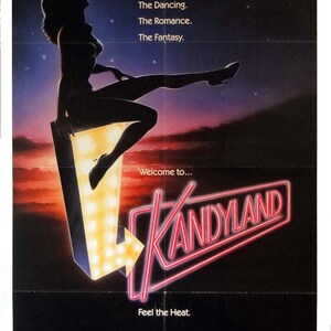 May include: Movie poster for the film "Kandyland" featuring a woman in silhouette sitting on a neon sign with the word "Kandyland" in red neon letters. The poster has a dark blue background with stars and a shooting star. The text "Welcome to..." and "Feel the Heat." are also on the poster.