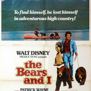 May include: A movie poster for the film "The Bears and I" starring Patrick Wayne. The poster features a snowy mountain range in the background, a man in a plaid shirt and blue jeans walking with two bears on leashes, and the text "To find himself, he lost himself in adventurous high country!"