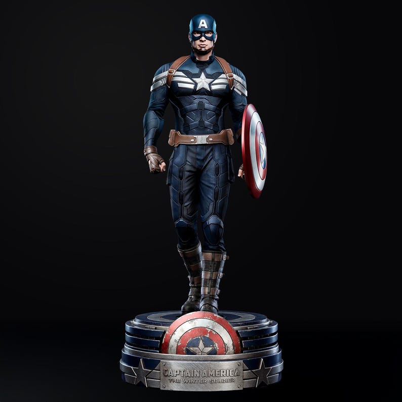 Op de afbeelding: Een Captain America-beeld in een dynamische pose, gekleed in een blauw-wit kostuum, met een schild. Het beeld heeft een bruine riem en banden. De basis toont het Captain America-schild en de tekst "CAPTAIN AMERICA THE WINTER SOLDIER."