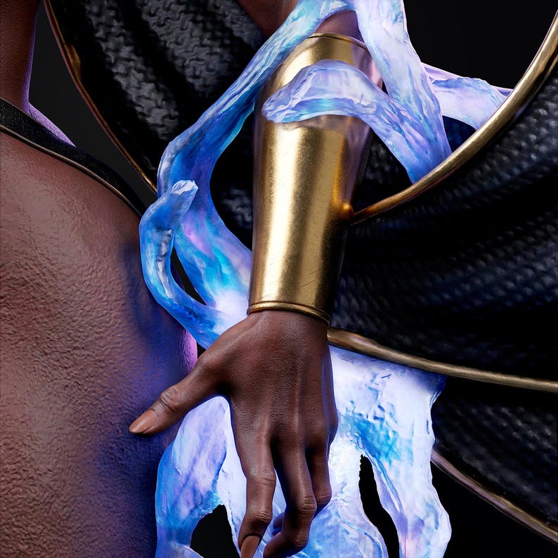 Pu&ograve; includere: Primo piano del braccio di una figura adornato da un bracciale dorato e da un effetto di energia blu traslucida. La pelle scura contrasta con l'oro e il blu brillante, su uno sfondo scuro. L'immagine suggerisce un tema fantasy o supereroistico.